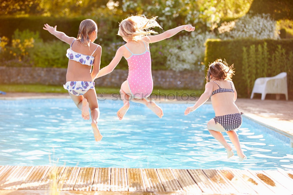 Similar – Teen girl spraying little sister in garden