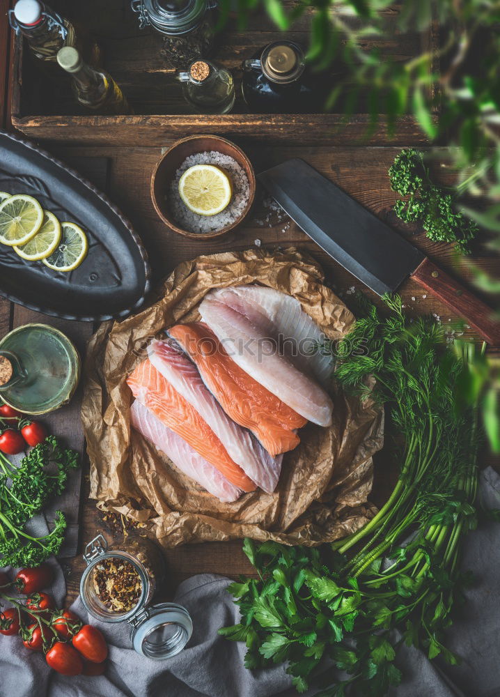 Similar – Salmon fish fillets on chopping board with fresh vegetables