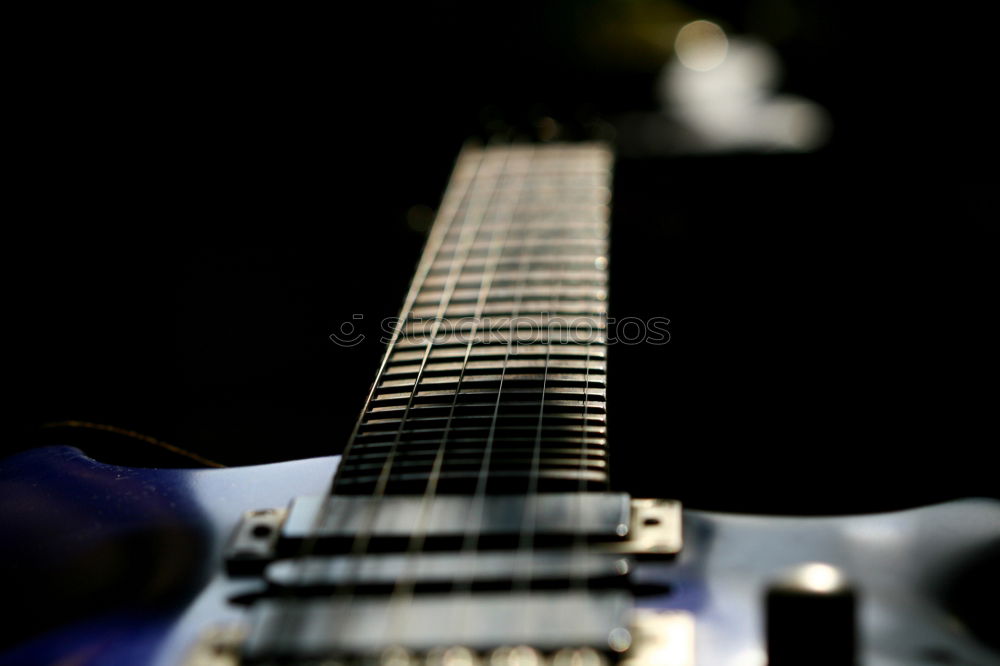 Similar – Image, Stock Photo A black electric guitar on a wooden board table photographed from the guitar head perspective. The focus is on the side holder and knob.