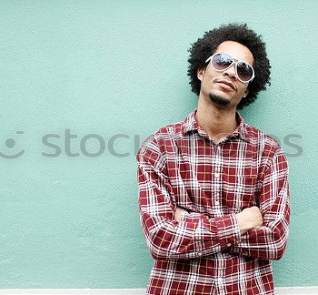 Similar – Image, Stock Photo Young beautiful Afro-American woman posing and smiling while standing against brick wall