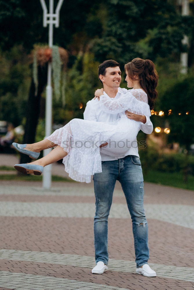 Similar – Couple embracing on evening street