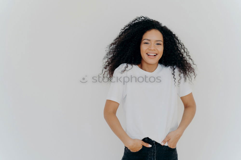 close up of a pretty black woman with curly hair smiling and lying on bed looking away