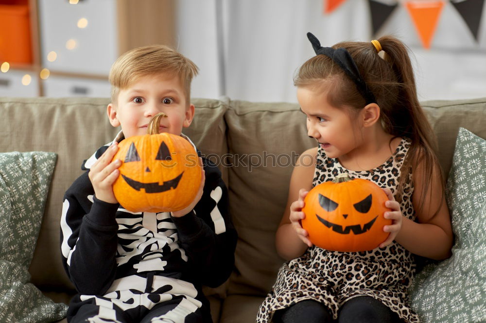 Image, Stock Photo Happy children disguised decorating a pumpkin at home.