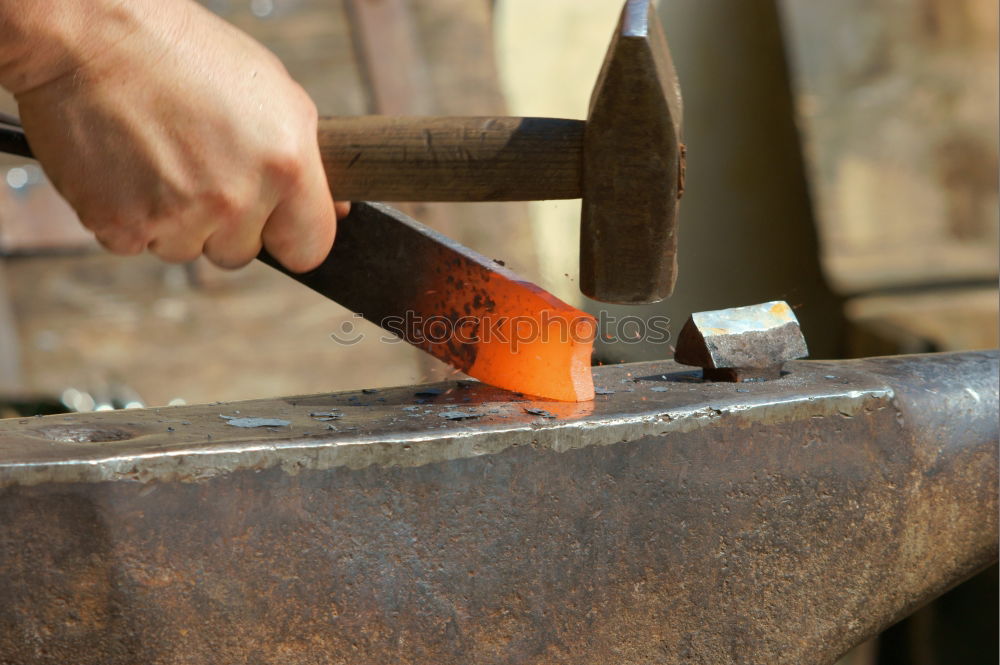 Similar – Blacksmith produces a horseshoe on an anvil with a hammer