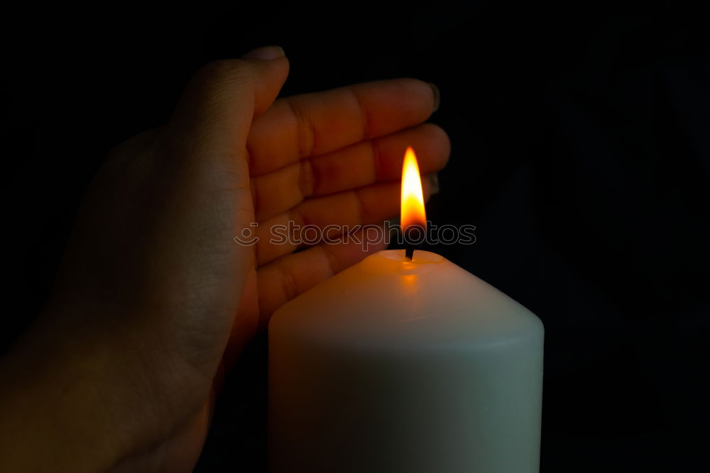 Similar – A single red burning candle held by a girl