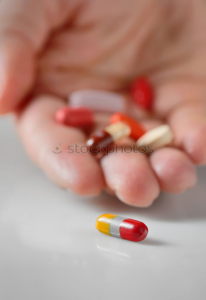 Hand and various pills on it. Human skin and medicines.