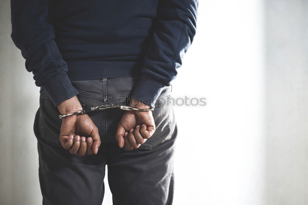 armed policeman with handcuffs from behind, partial view