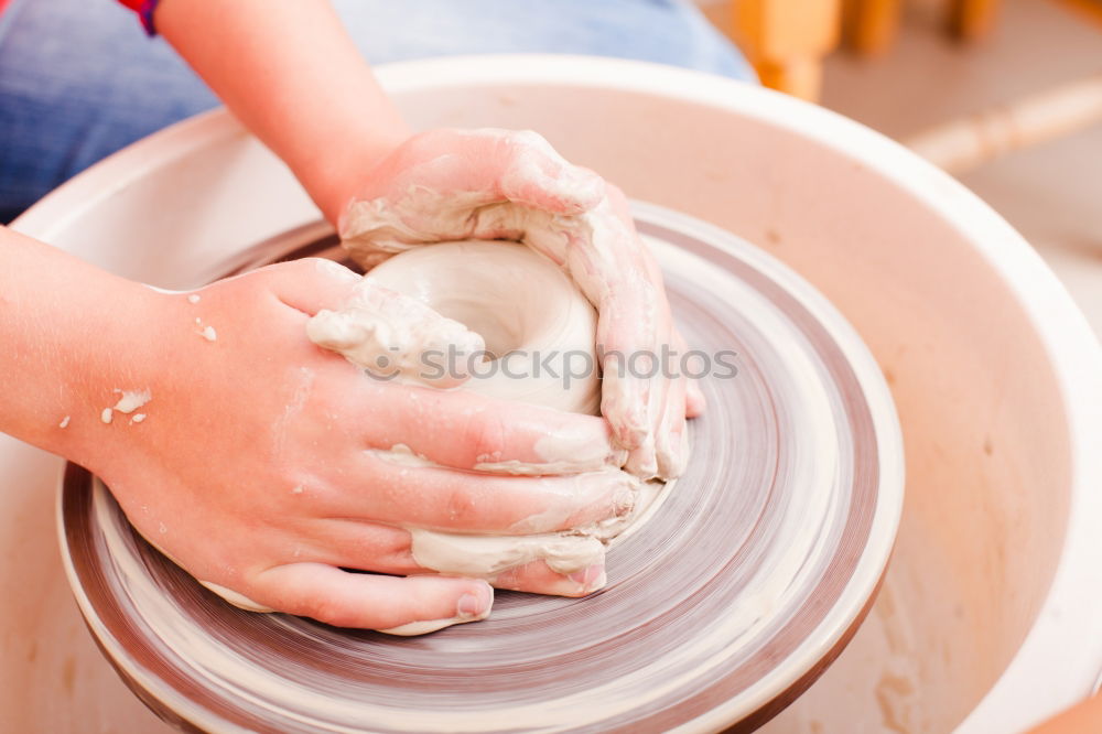 Similar – Image, Stock Photo Young female sitting by table and making clay or ceramic