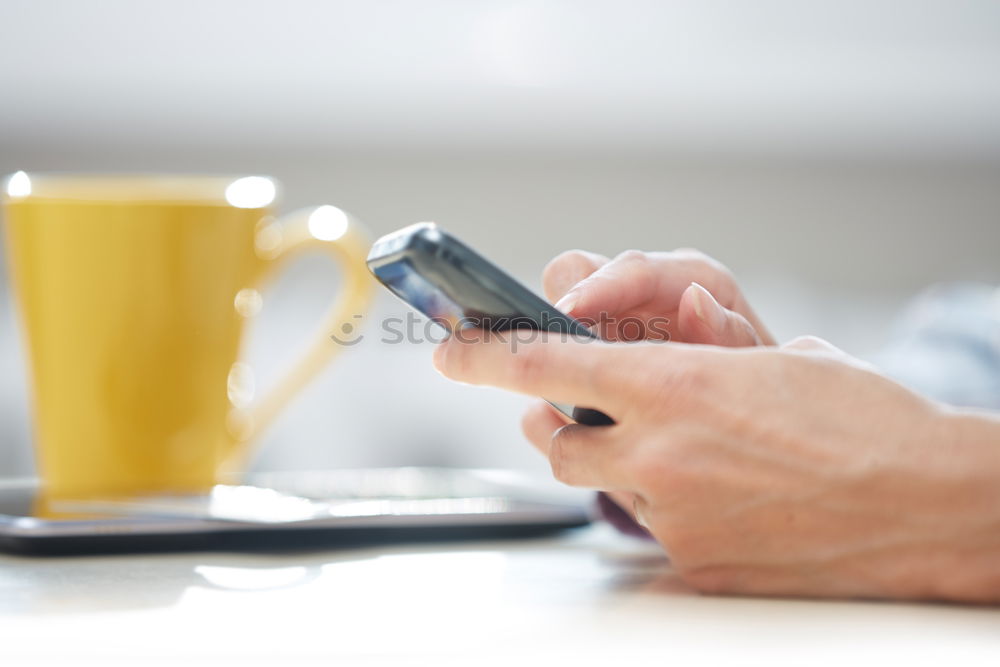 Woman hands using smartphone and writing notebook