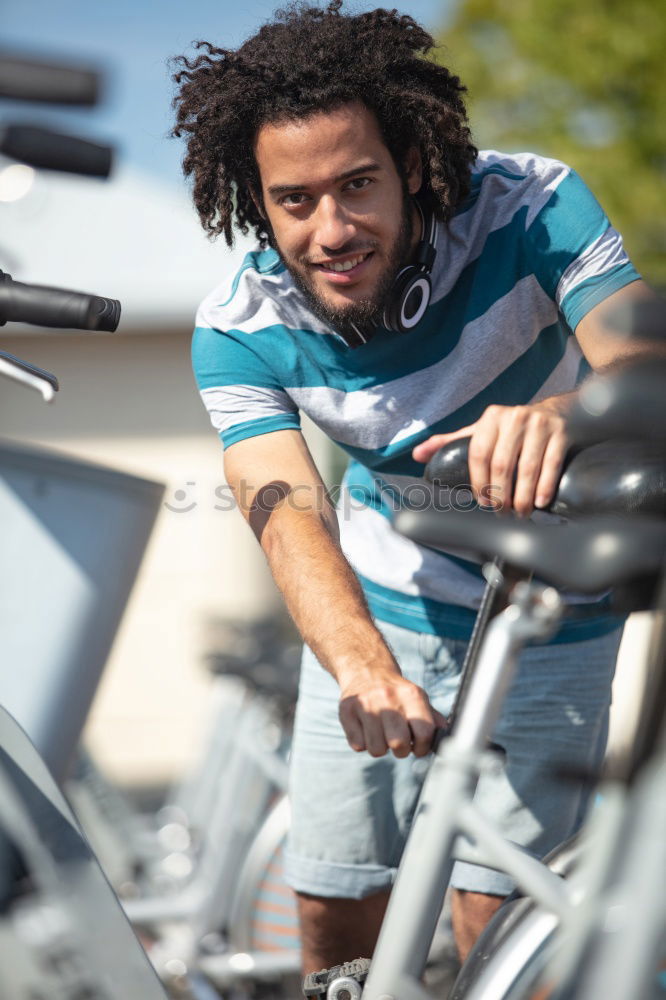 Similar – Handsome afro man walking with his bike.