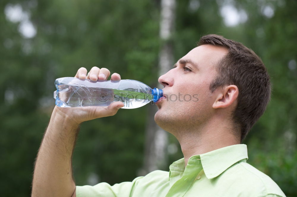 Fit young woman drinking bottled water