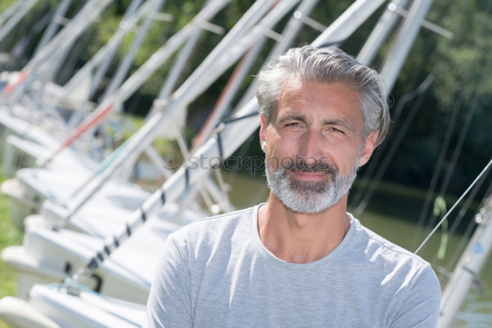 Similar – Portrait of a smiling senior with grey hair and grey beard in front of a grey sky