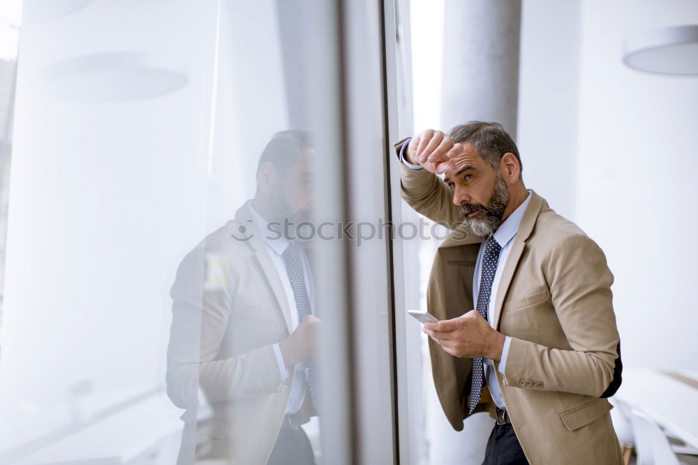 Similar – Geschäftsmann mit Blick auf das Smartphone im modernen Firmenbüro.