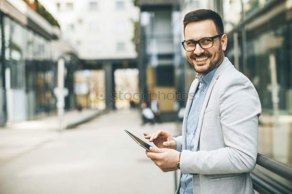 Similar – Image, Stock Photo Young smiling man looking at his smartphone in the street