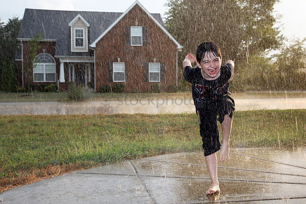 Similar – Happy little boy pouring water from a hose.