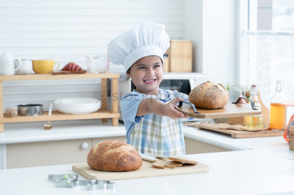 Boy in cook hat in kitchen