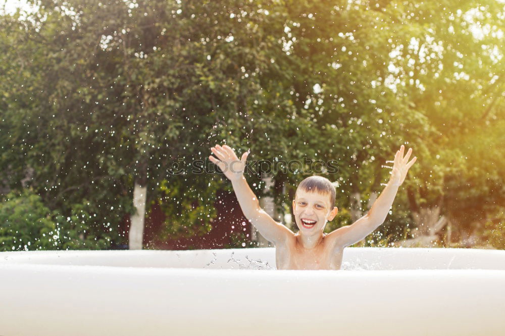 Similar – Teen girl spraying little sister in garden