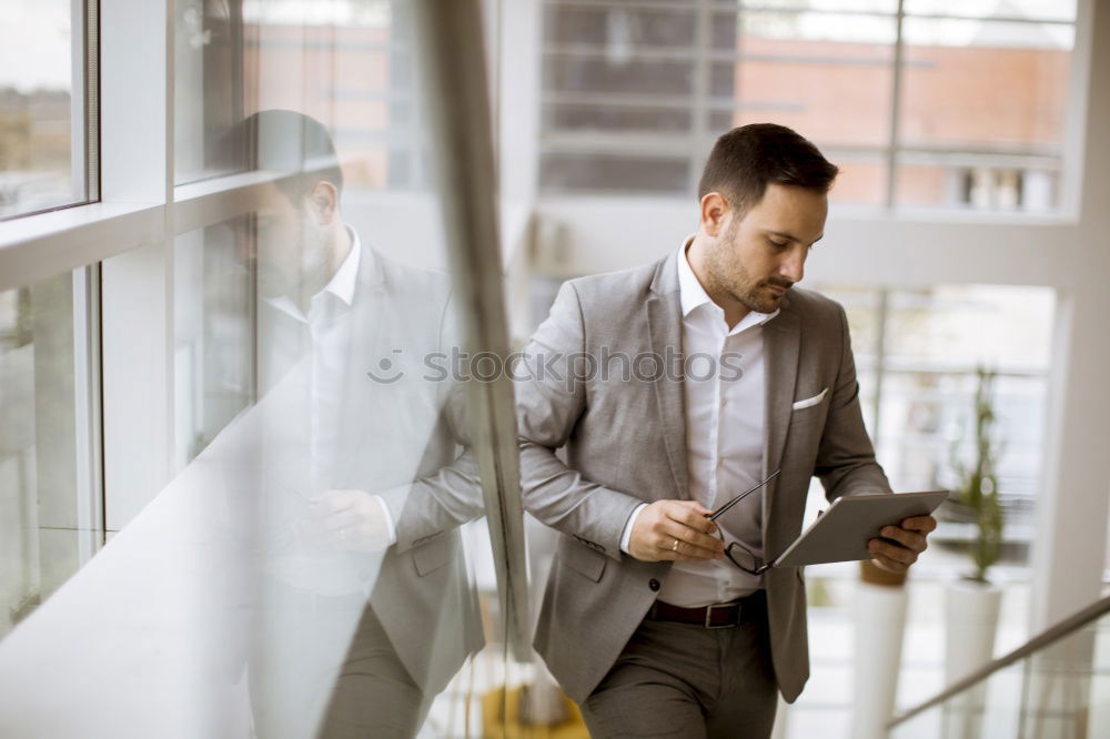 Similar – Geschäftsmann mit Blick auf das Smartphone im modernen Firmenbüro.