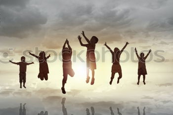 Four people jumping at sunset.