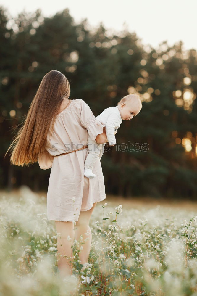 Foto Bild Mutter hält ihren kleinen Sohn in die Luft und das Baby lacht.