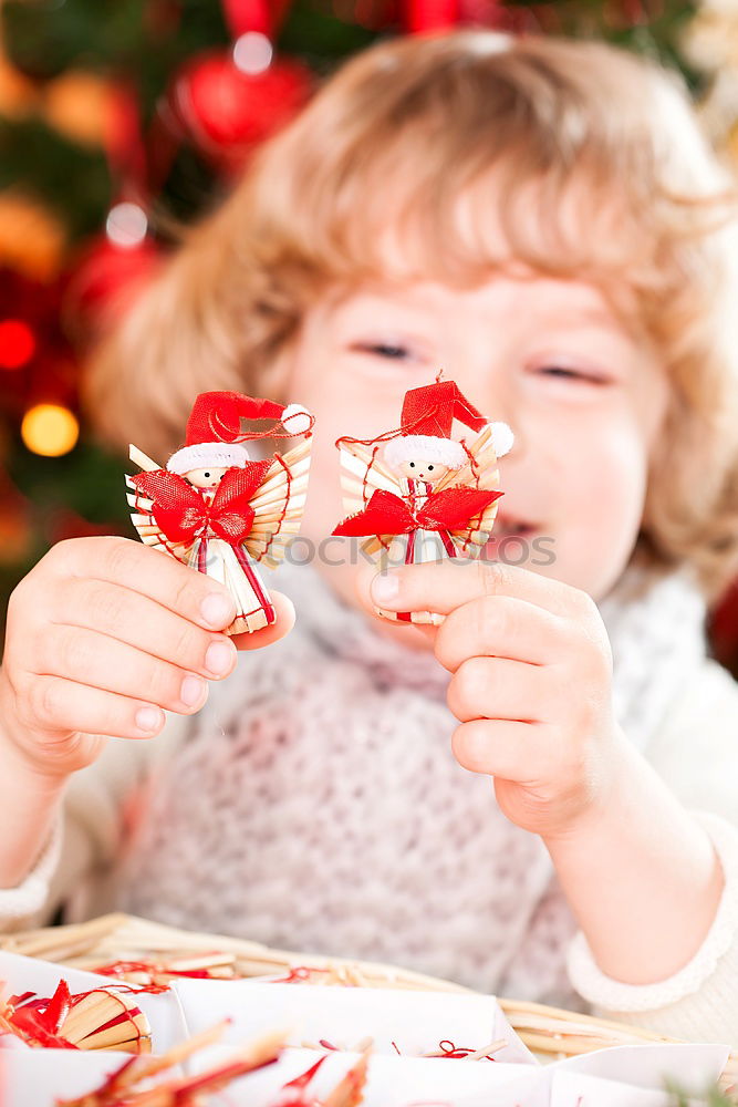 Mother and son decorating Christmas biscuits at home