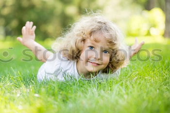 Similar – Image, Stock Photo Funny, funny, cheerful, happy, funny blonde girl outside in the garden, looks up and stretches both arms up to the tree. Little joker does nonsense, sticks out her tongue, in nature, in the park under the tree.