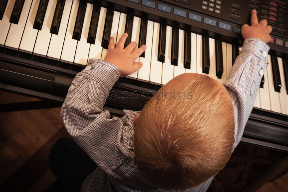 Similar – Toddler plays piano with delicate hands