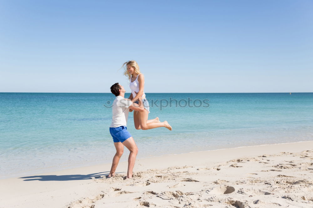 Father and son playing on the beach at the day time. They are dressed in sailor’s vests and pirate costumes. Concept of happy game on vacation and friendly family.