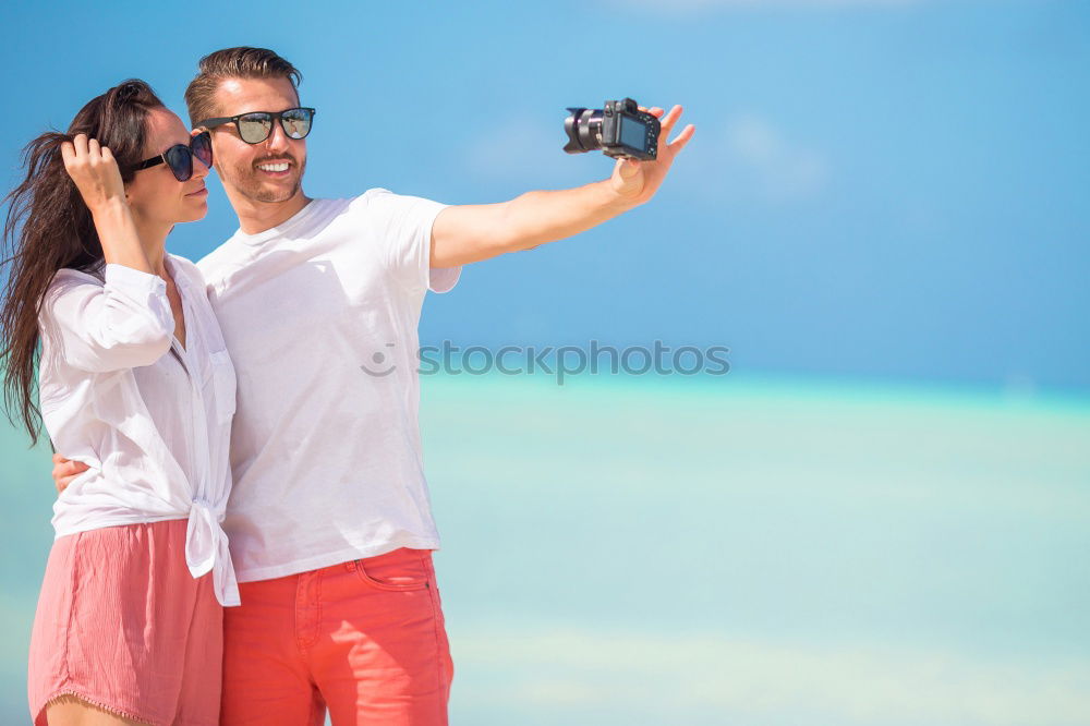 Similar – Happy young man and woman in fashionable sunglasses taking cellphone selfie on background of defocused blue sea. Vacation photos