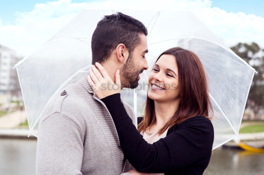 Similar – Young couple looking at each other under umbrella outdoors