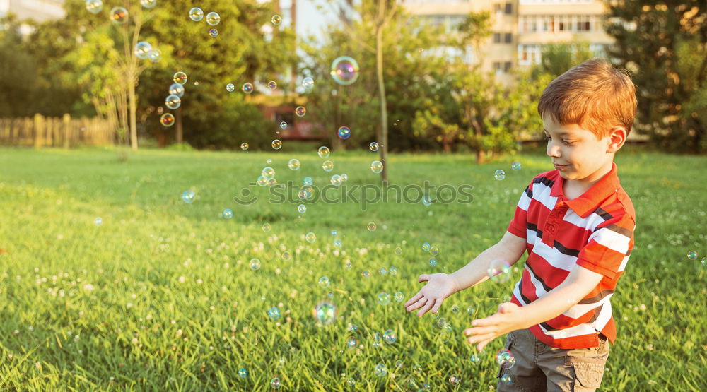 Similar – Image, Stock Photo Happy boy playing with soap bubbles in the park