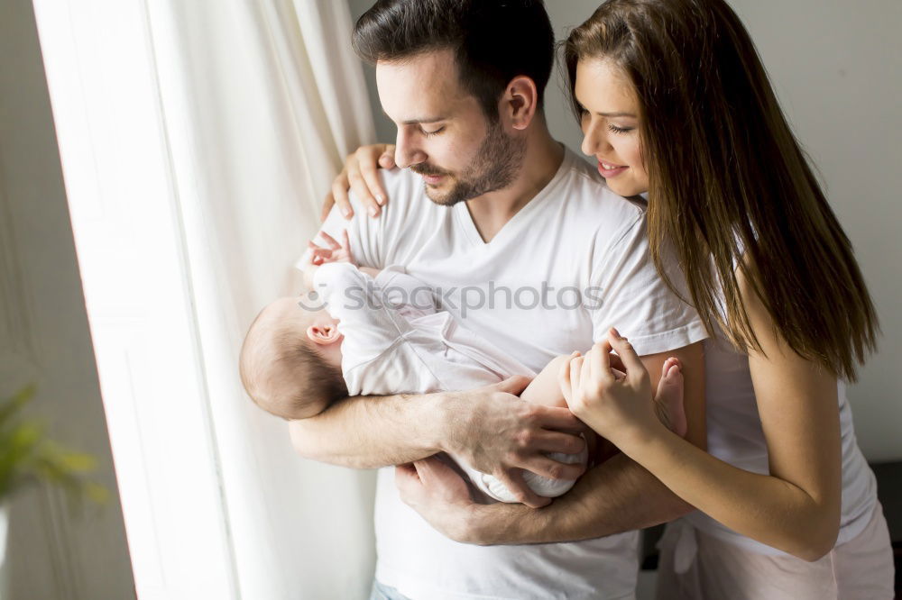 Similar – Image, Stock Photo Couple embracing a newborn over dark background