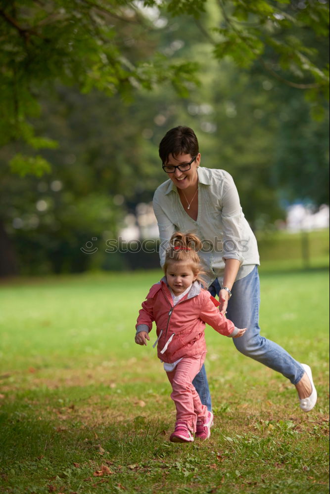 Similar – Mom reading a book her little daughter