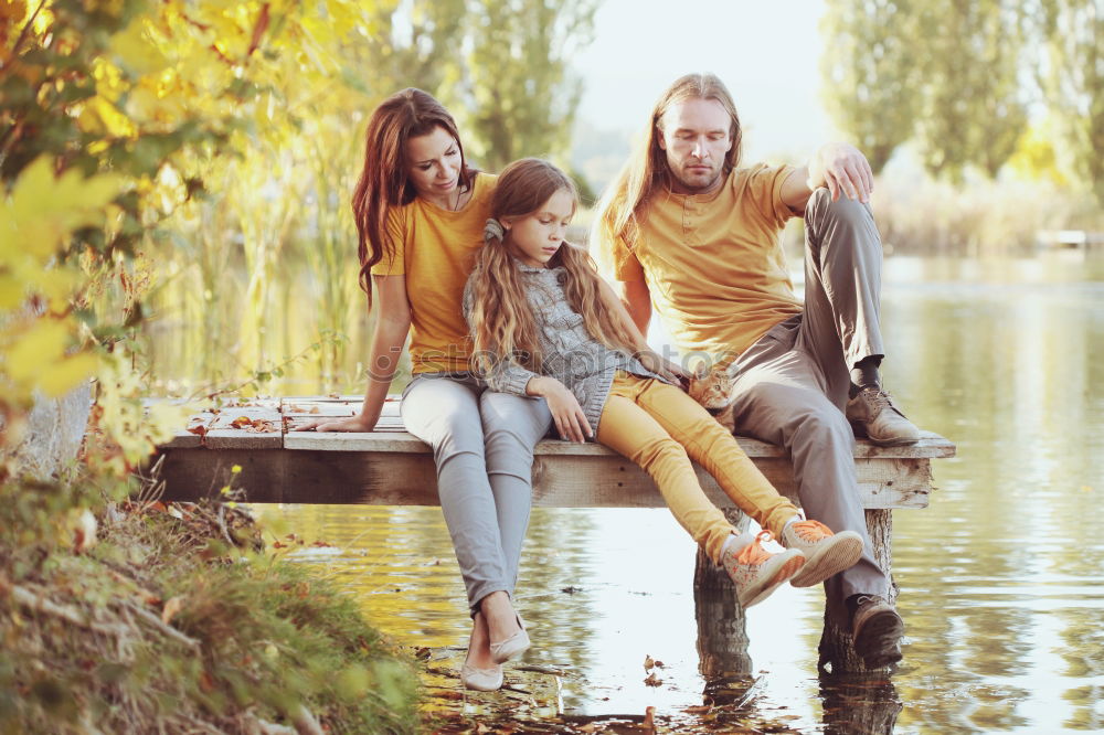 Similar – Family spending vacation time together having a snack sitting on jetty over the lake on sunny day in the summertime