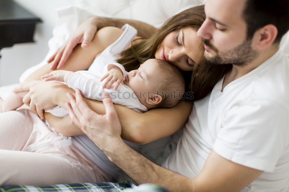 Similar – Image, Stock Photo Couple embracing a newborn over dark background