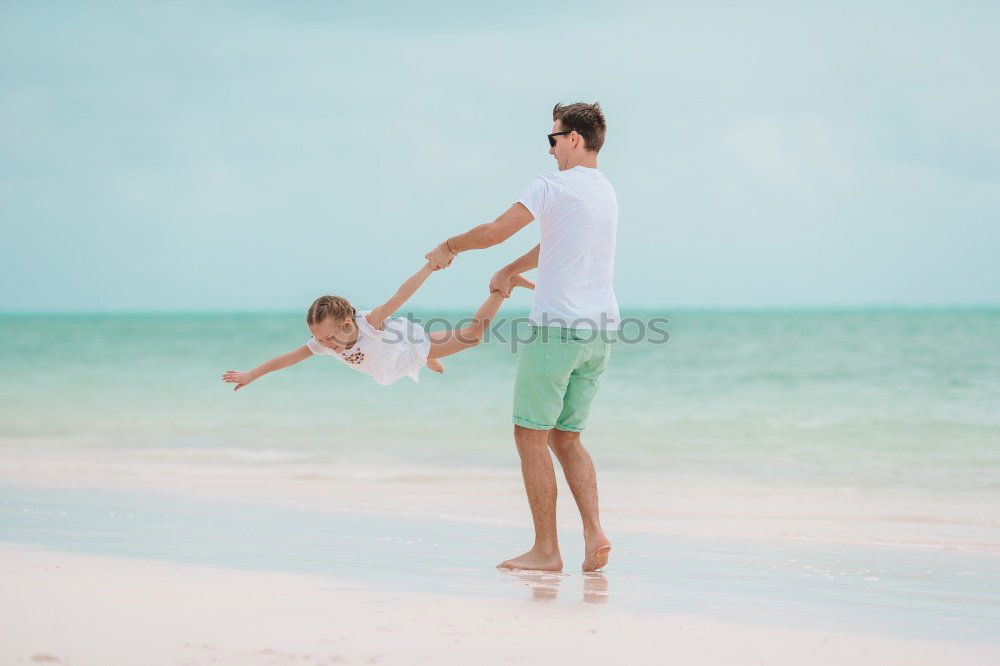 Similar – Father and daughter playing on the beach at the day time.