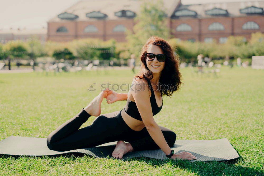 Image, Stock Photo Happy fit young woman does stretching workout on fitness mat practices yoga outside dressed in activewear has strong body breathes fresh air outdoor leads active lifestyle. Sport fitness concept