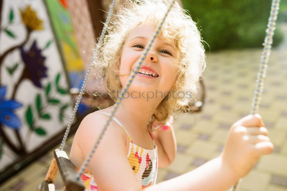 Similar – Cute black boy having fun on a swing in his parents garden