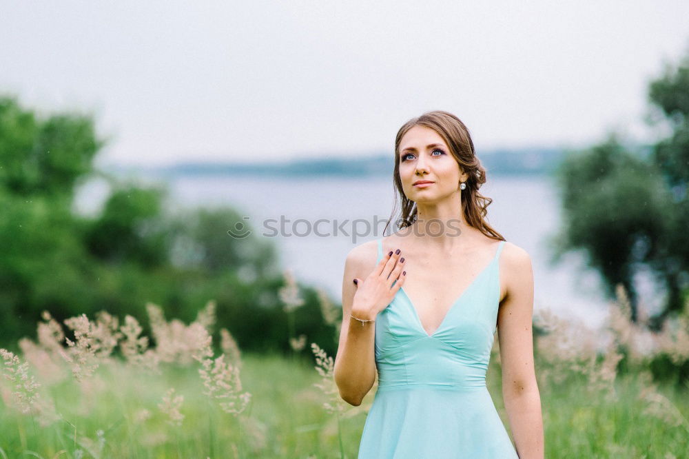 Similar – Brunette woman leaning on handrail at river