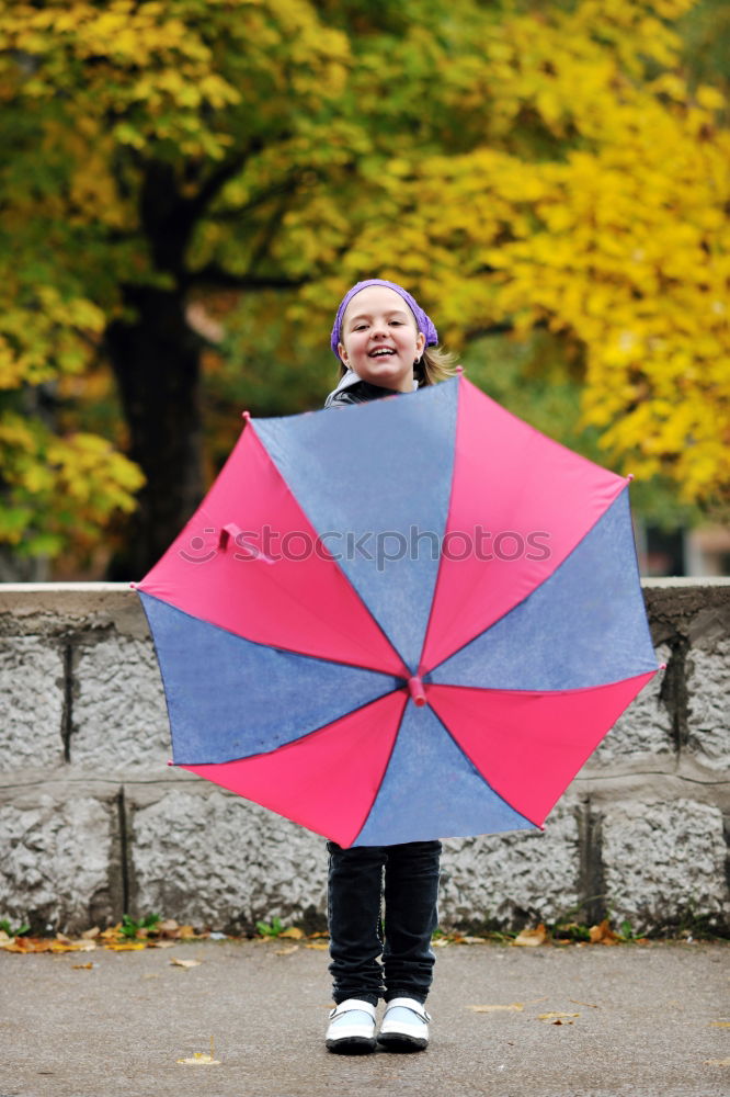 Similar – Image, Stock Photo Child in a raincoat with umbrella crouched down playing and laughing in a puddle