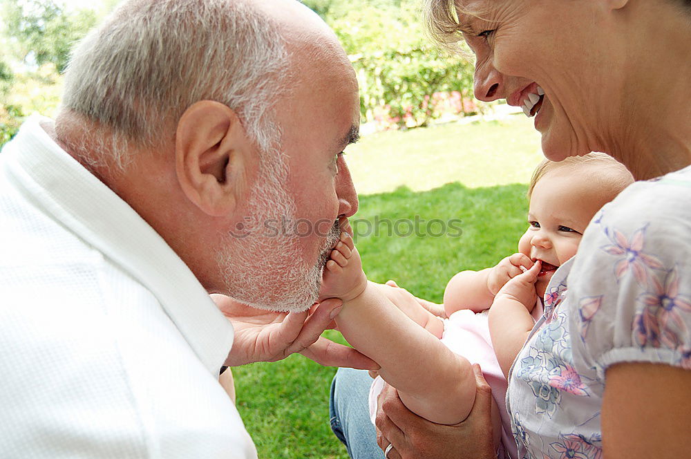 Similar – Image, Stock Photo Baby girl playing with hat of senior man over a nature background