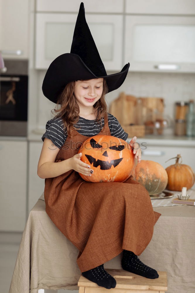 Similar – Image, Stock Photo Happy children disguised decorating a pumpkin at home.