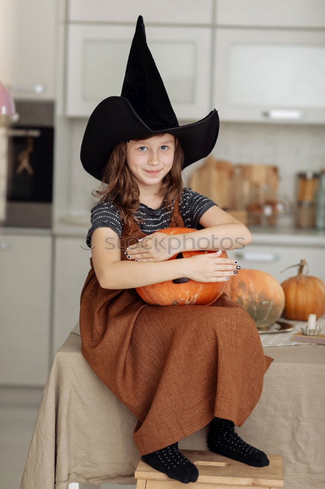 Similar – Image, Stock Photo Beautiful girl disguised of witch decorating a pumpkin at home.