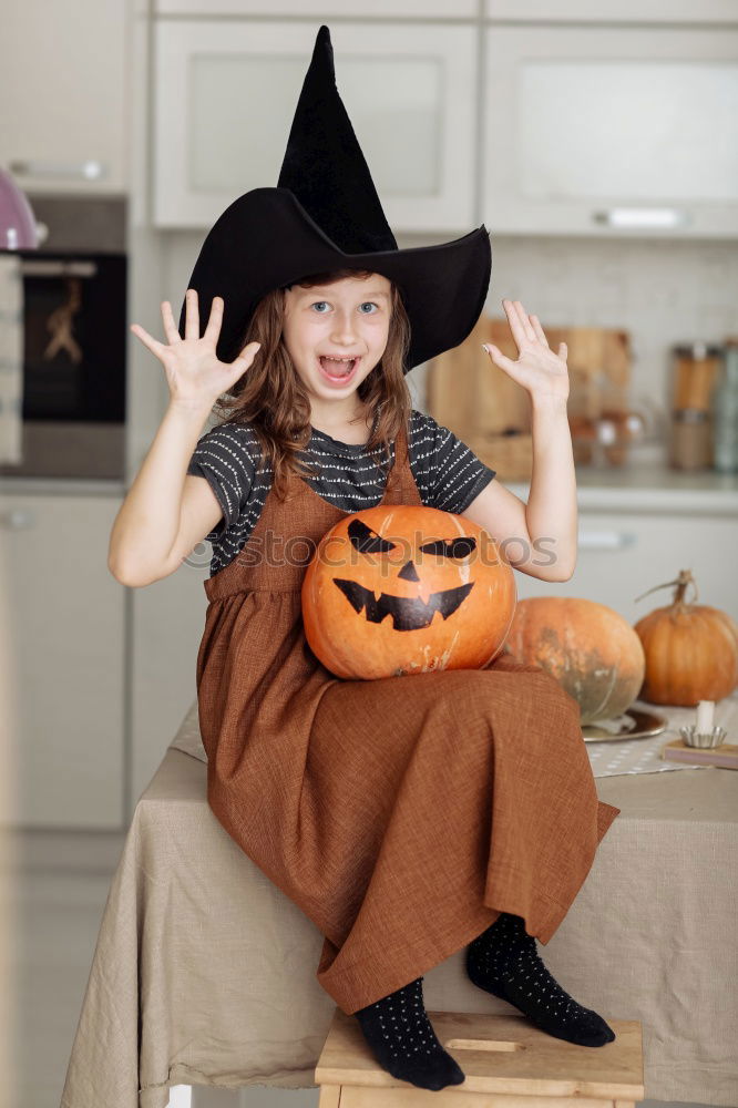 Similar – Image, Stock Photo Beautiful girl disguised of witch decorating a pumpkin at home.