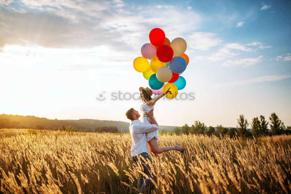 Similar – boy running through the field with balloons