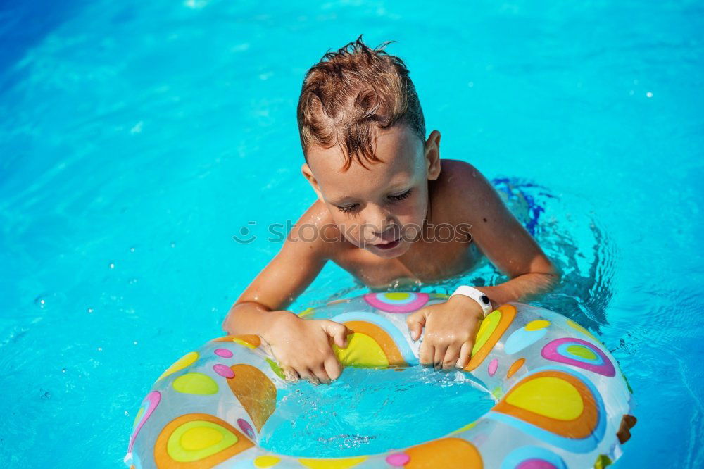 Similar – One little happy boy playing on the inflatable circle in swimming pool at the day time. Concept of friendly family.