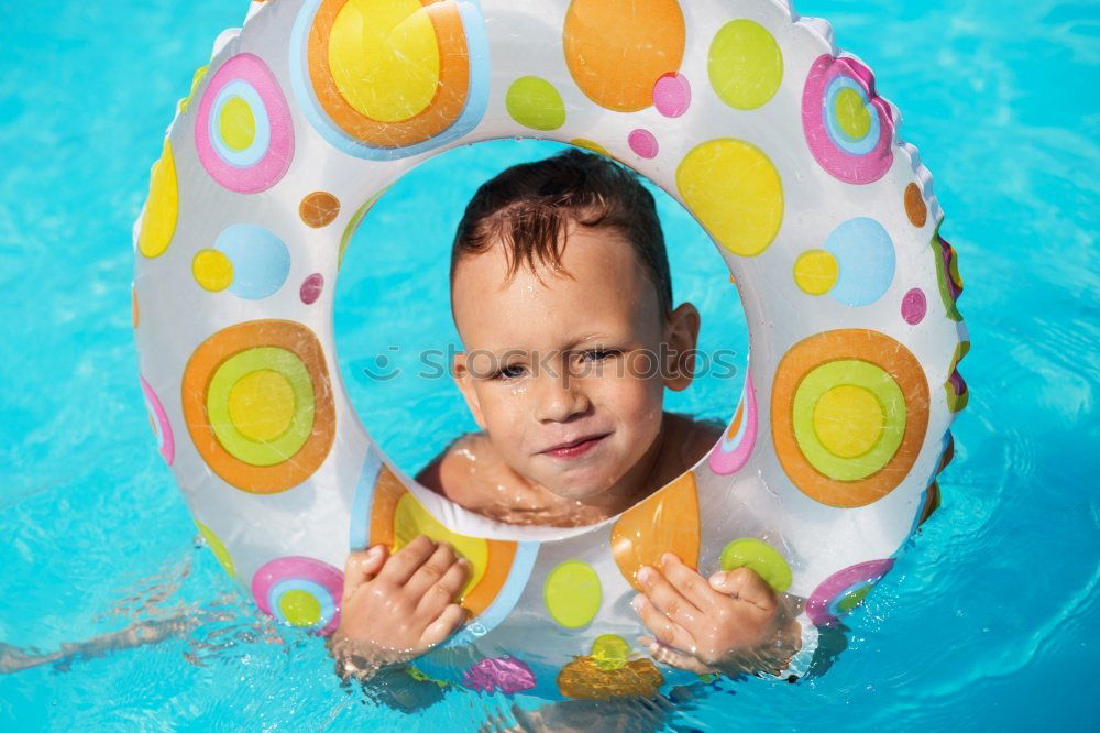 Similar – One little happy boy playing on the inflatable circle in swimming pool at the day time. Concept of friendly family.