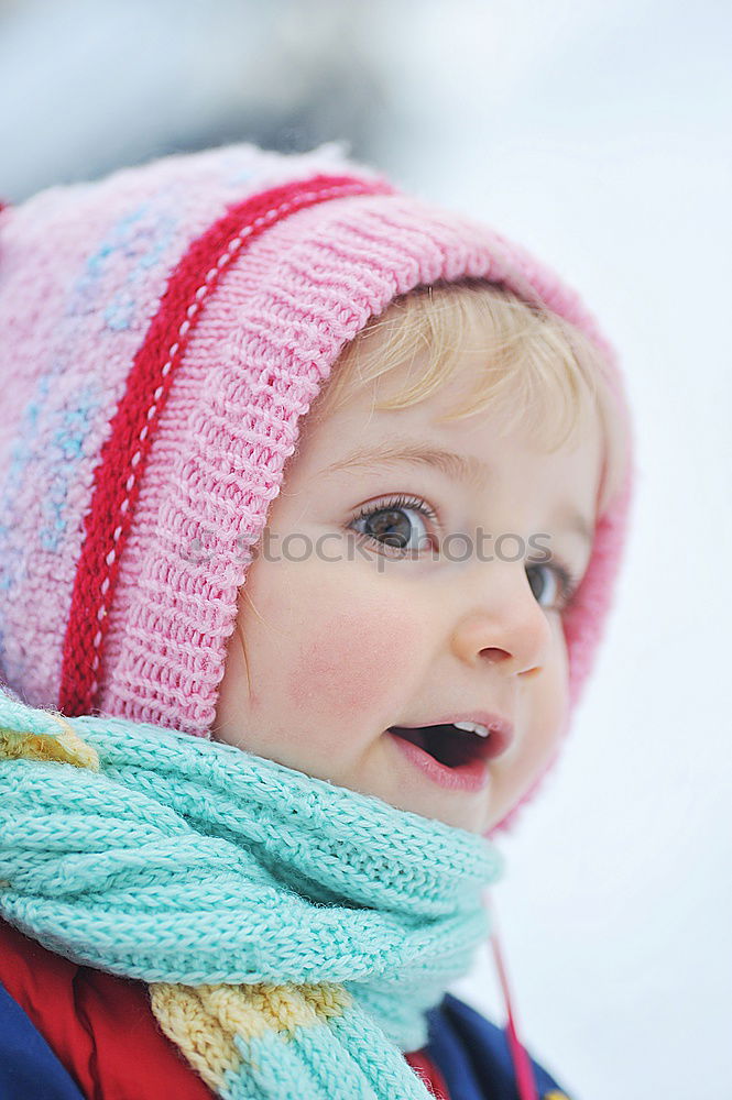 Similar – baby girl in knitted scarf walking in winter forest