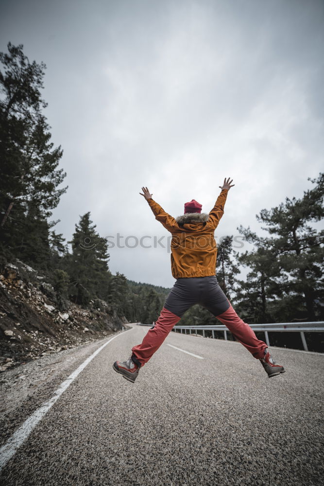 Image, Stock Photo jumping woman on a country road with mountains in the background