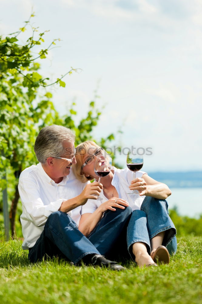 Similar – Image, Stock Photo 2 seniors in love are sitting on a bench in the vineyard and look into the Ahr valley. The man points to something.